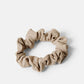 Beige scrunchie i en smalare modell. Sydda av överblivet tyg från tillverkningen av våra kjolar. Återvunnet tyg.